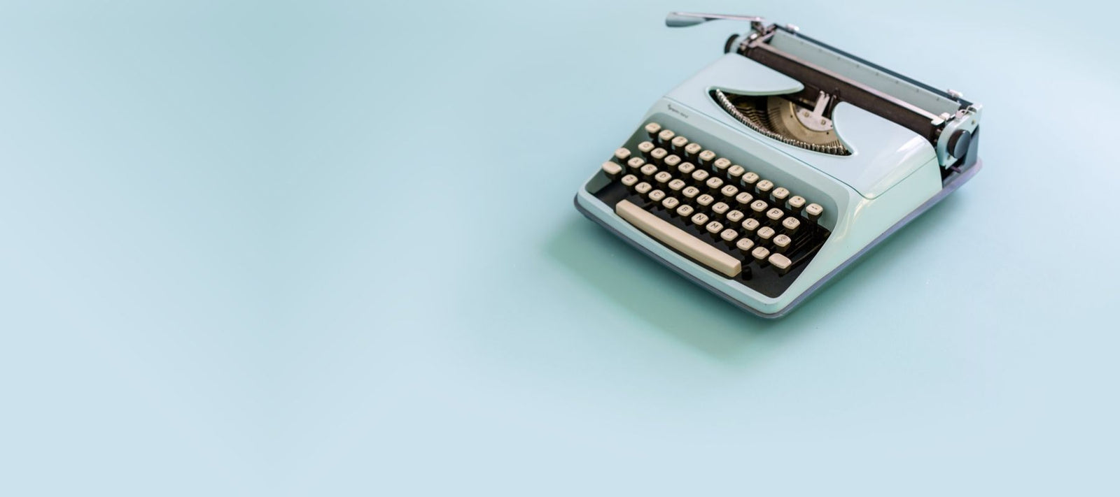 Sky blue old fashioned typewriter with sky blue background.
